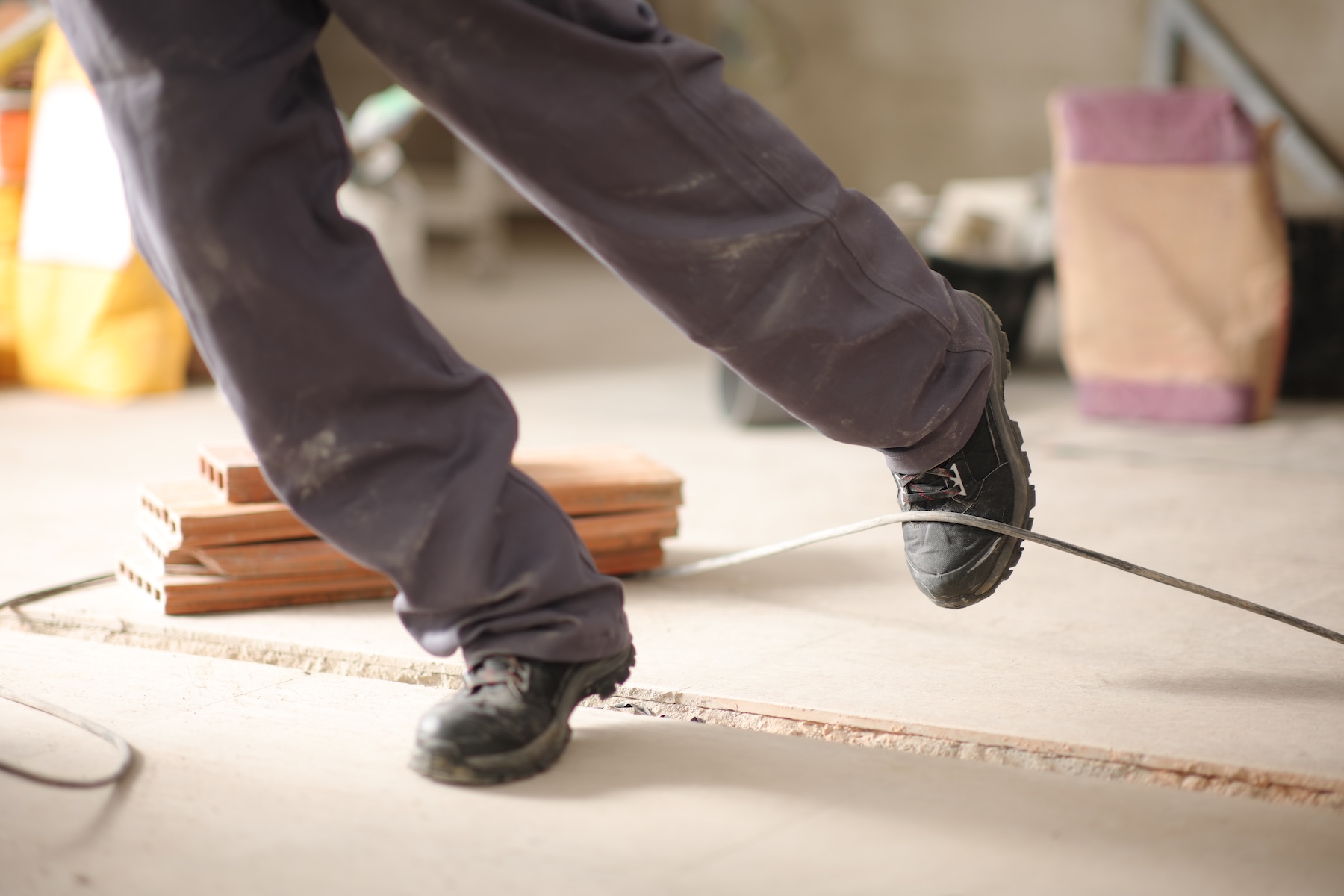 Construction worker tripping over a cord on a construction site