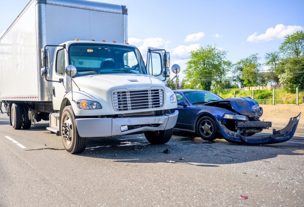 Collision of a semi truck with box trailer and a passenger car on the highway