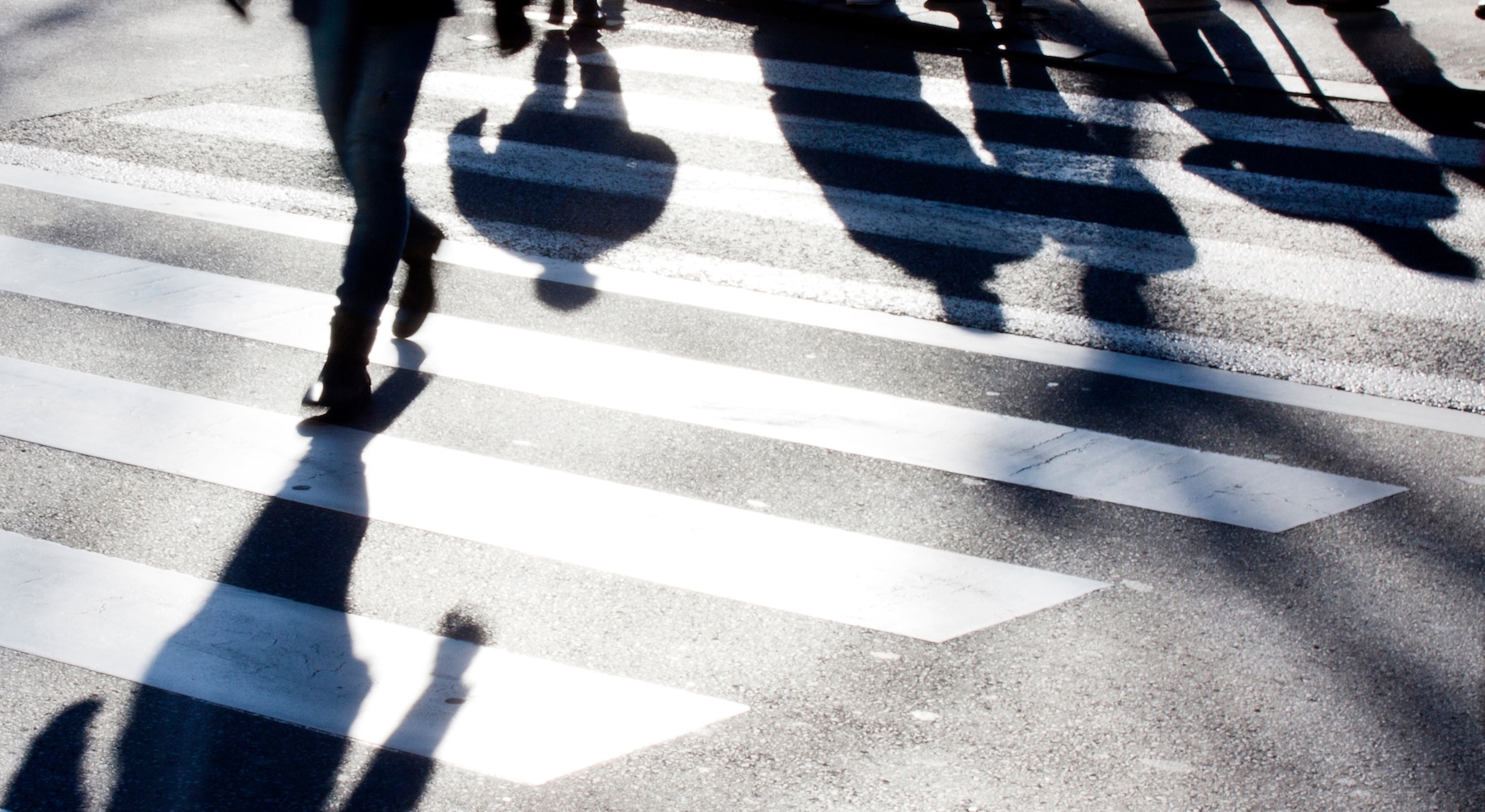Pedestrian crossing area with shadows of people crossing the street