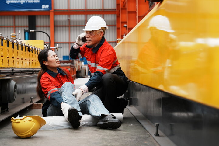 Female worker who fell on worksite being helped by manager